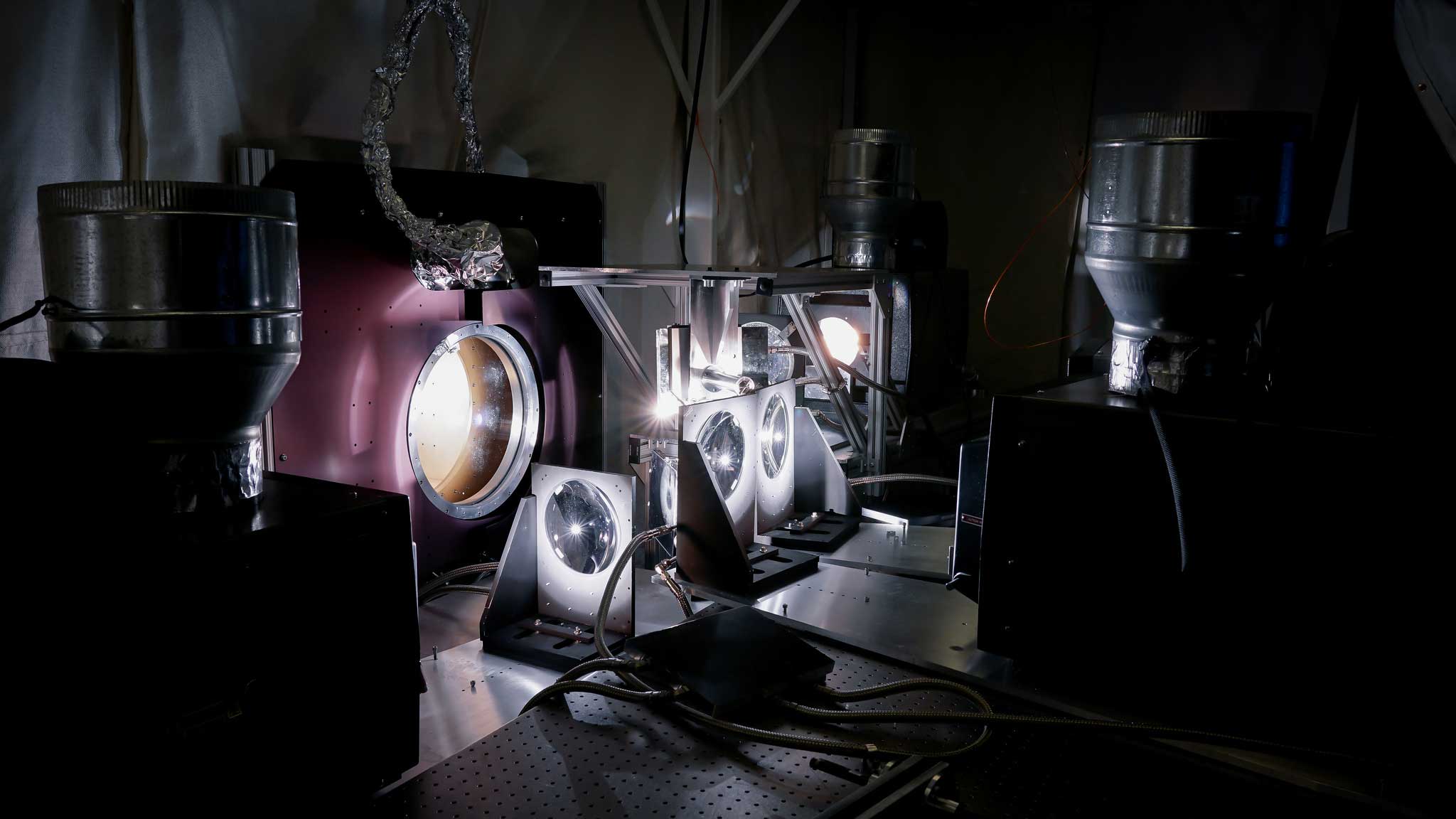Researchers use a quartet of IMAX projectors to create the light and heat the Parker Solar Probe cup will experience during its trips through the sun's atmosphere. The cup sits inside a vacuum chambers set up in a lab at the Smithsonian Astrophysical Observatory in Cambridge, Massachusetts.