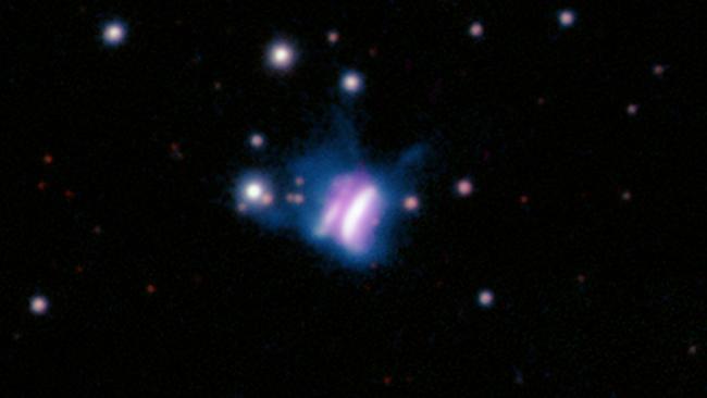 The center of this composite image shows IRAS 23077, likely the largest planet-forming disk ever seen, which looks like a giant cosmic butterfly.